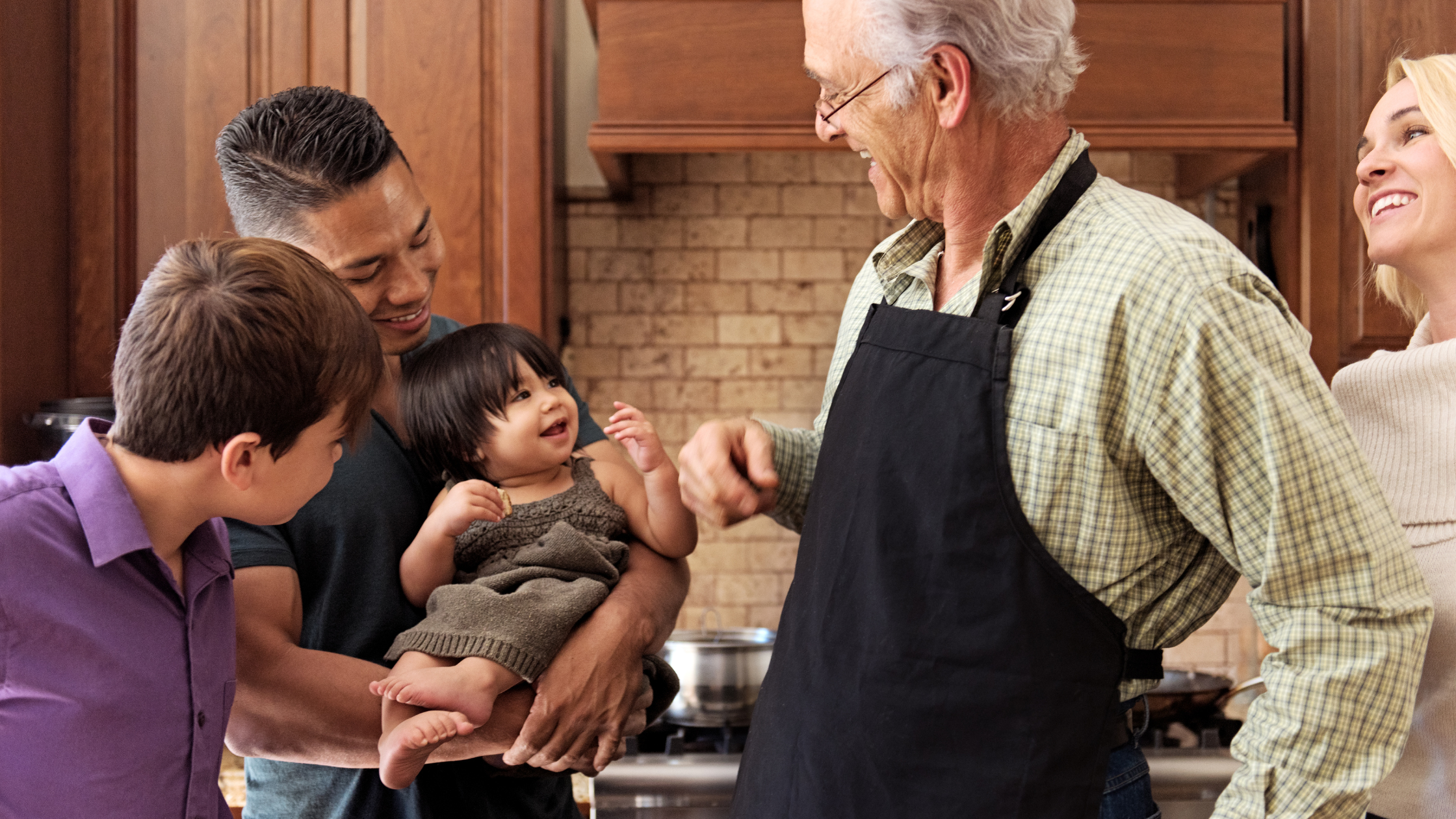 Family standing in the kitchen smiling